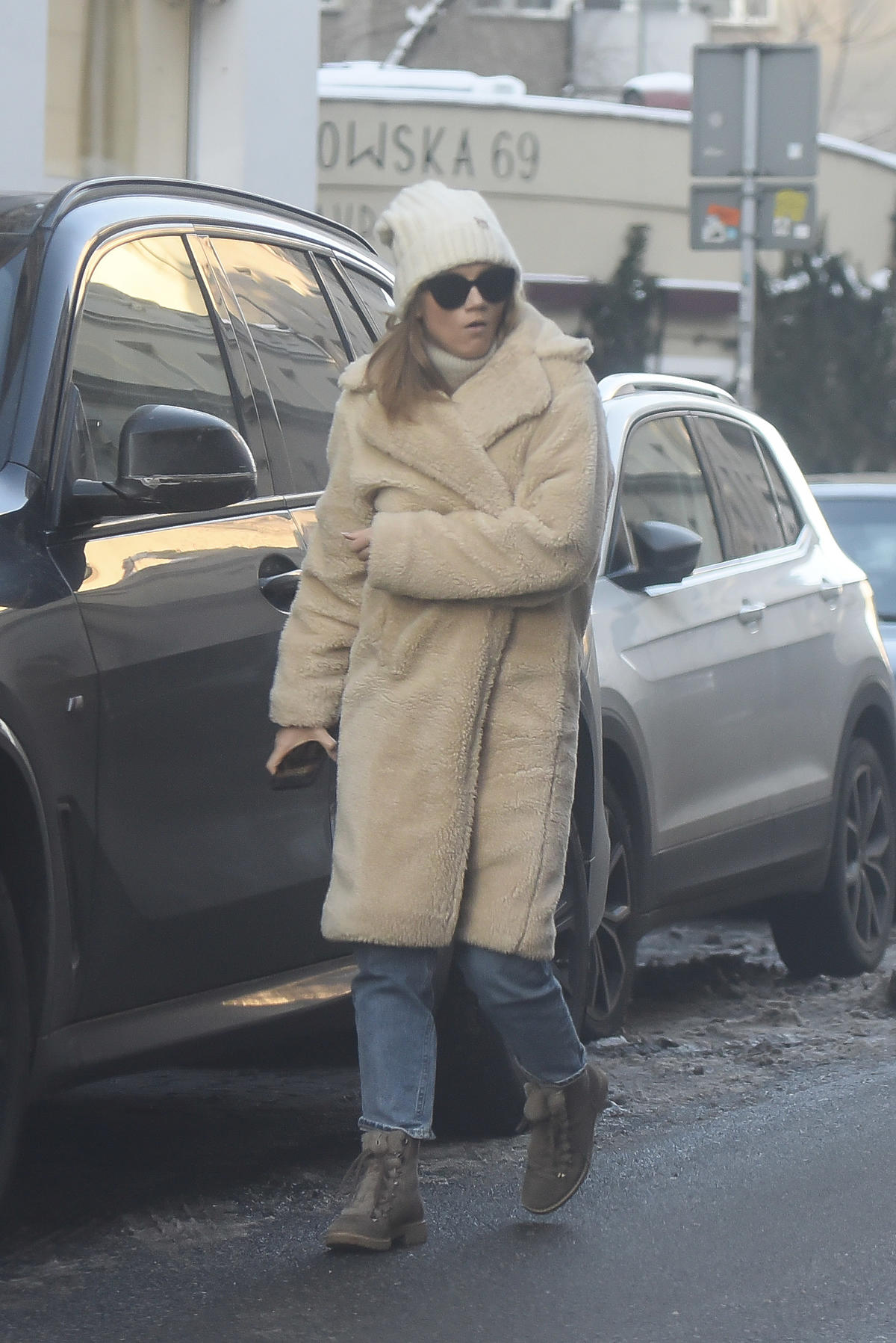 Agnieszka Kaczorowska wychodzi z auta w ciepłym, beżowym płaszczu 