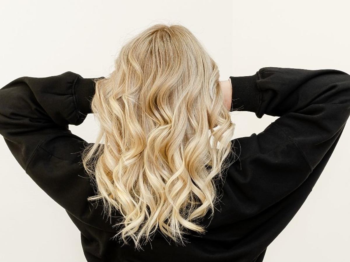 Kobieta pokazuje zadbane blond włosy