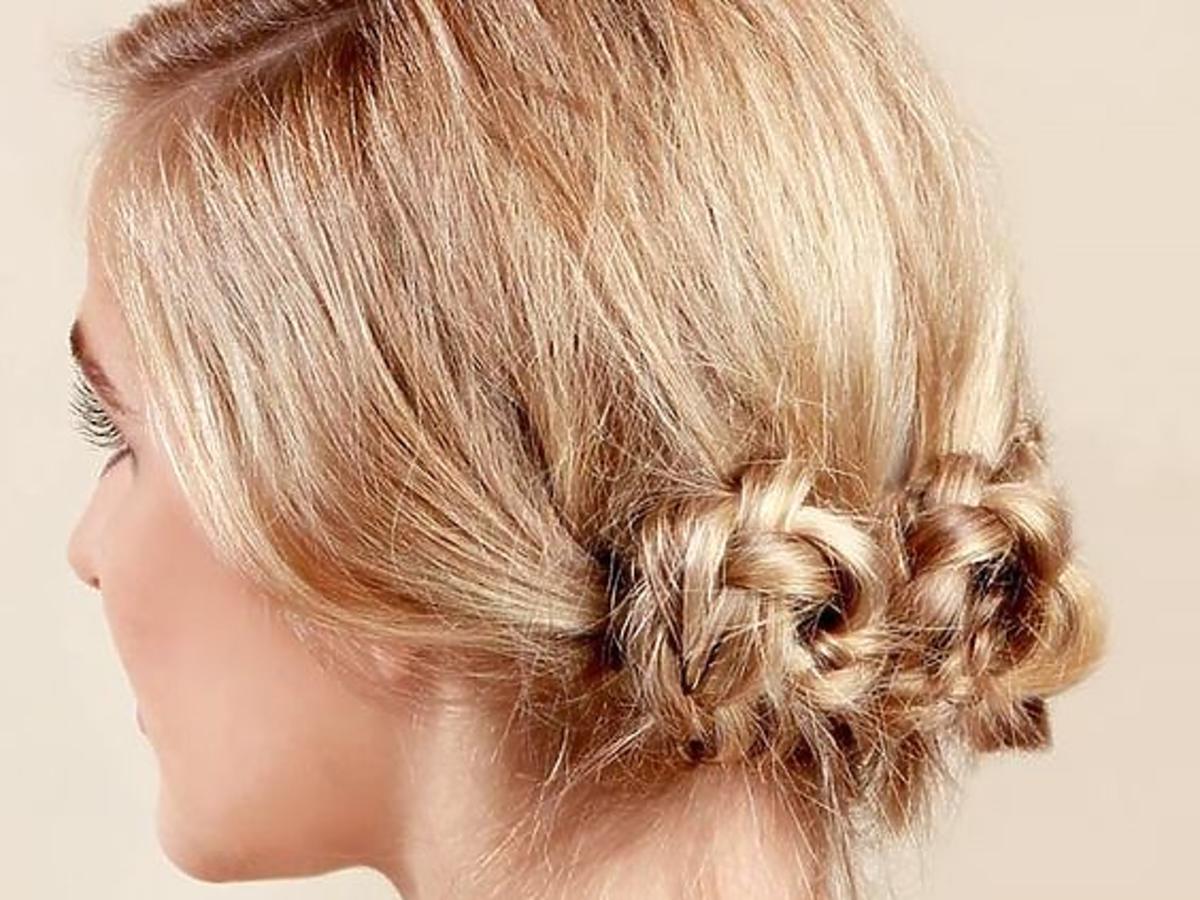 Blond włosy związane nad karkiem we fryzurę z zaplatanymi koczkami
