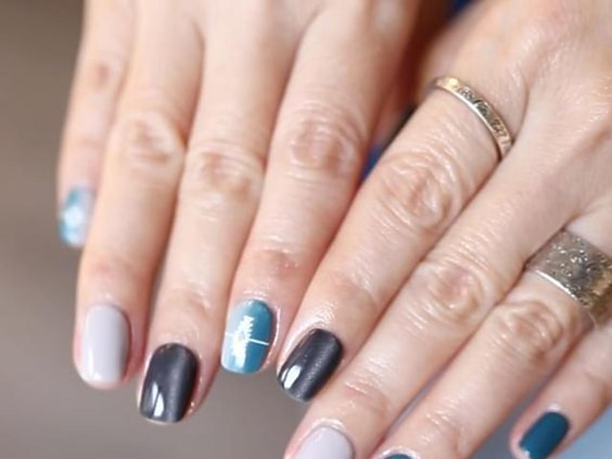 Dłonie z paznokciami w kształcie kwadratów z manicure w kolorze lazurowym i czarnym