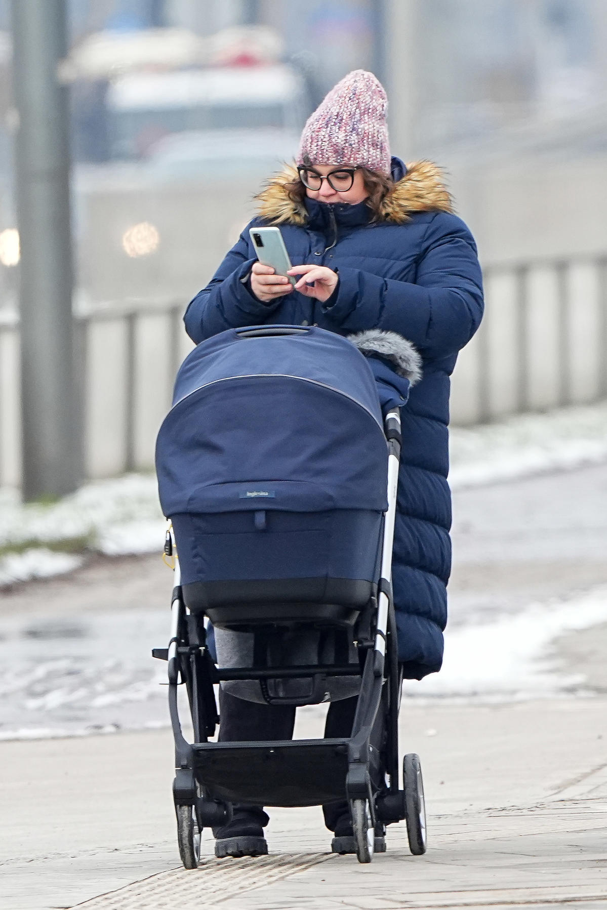 Dominika Gwit wpatrzona w telefon na spacerze z synem
