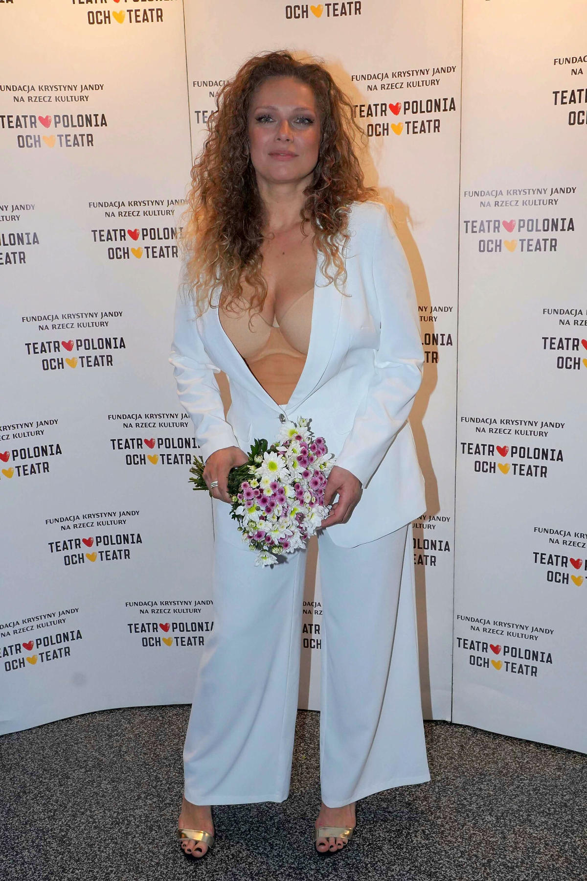 Joanna Liszowska w białym garniturze na premierze spektaklu