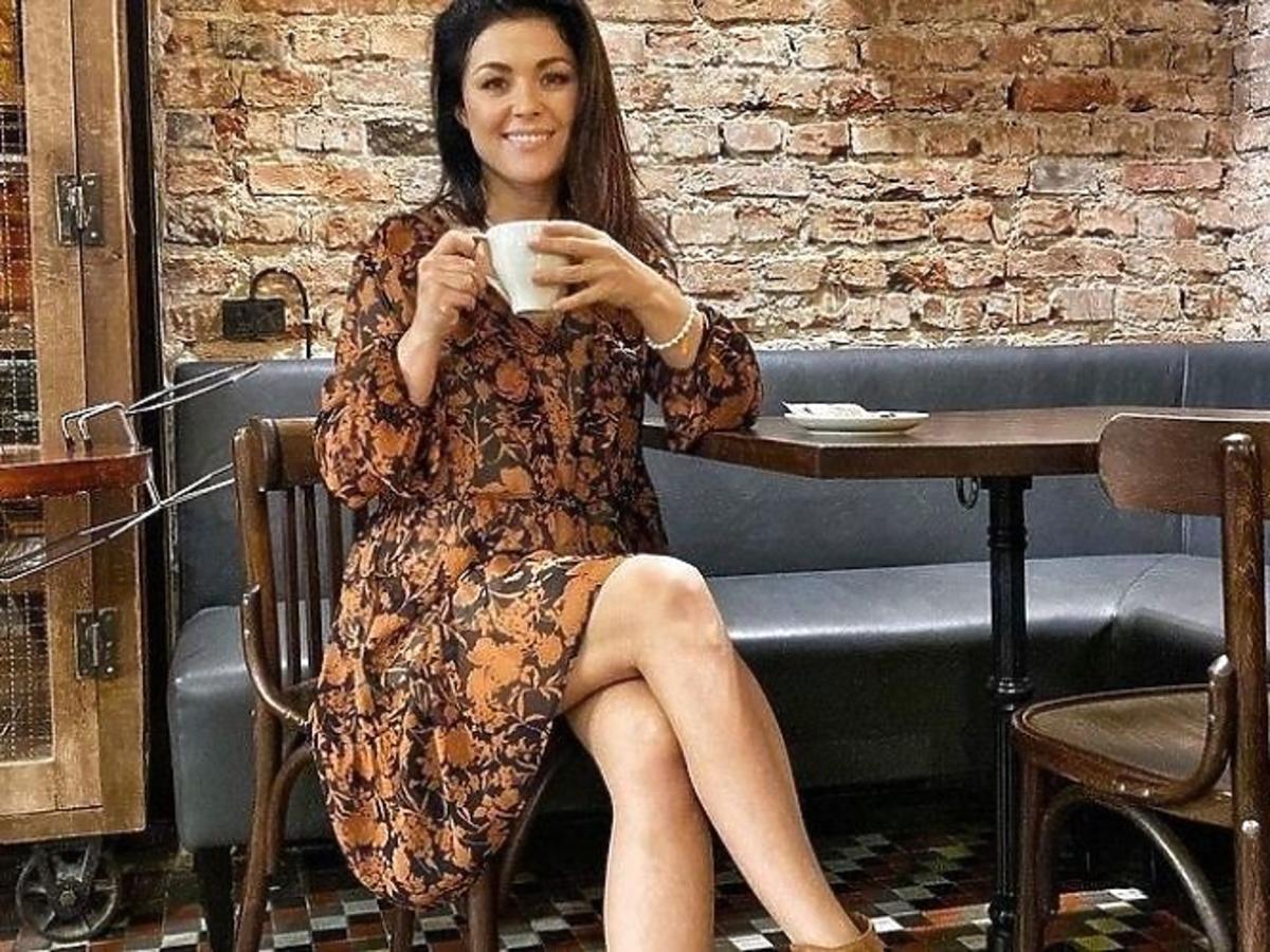 Katarzyna Cichopek w sukience midi, w kwiaty w kawiarni. 