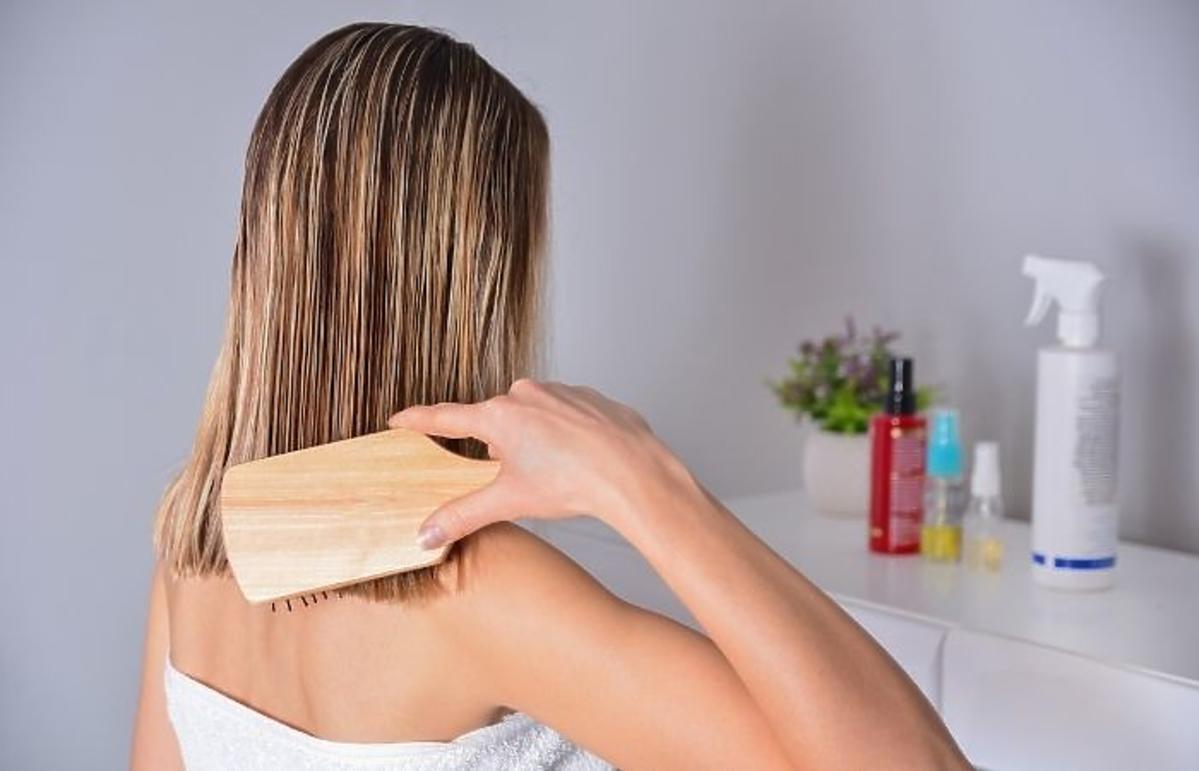 Kobieta czesząca włosy przed olejowaniem włosów