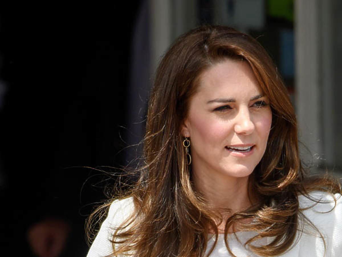 Księżna Kate w białej marynarce uśmiecha się szeroko