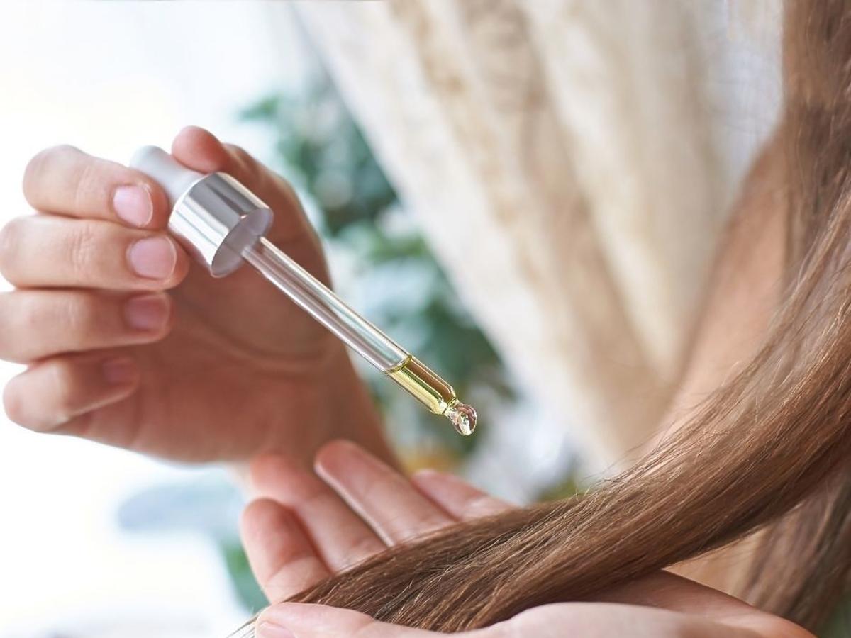 Olejowanie włosów: kobieta nakładająca olej na włosy