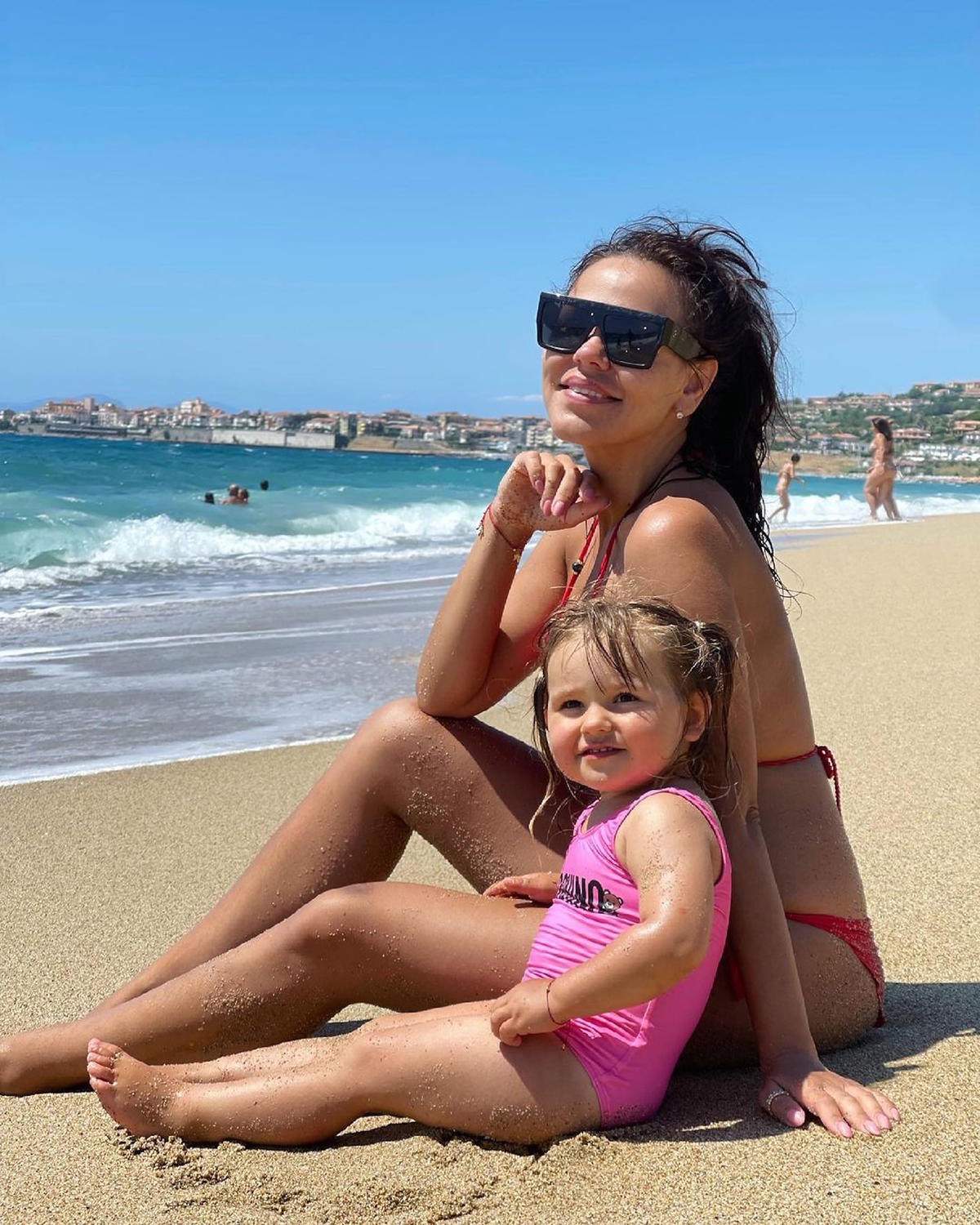 Sylwia Bomba z córką Antosią w różowym kostiumie na plaży