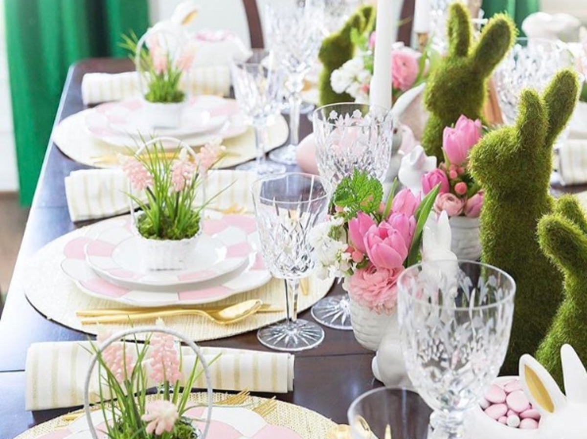 wielkanocna dekoracja na świątecznym stole: kwiaty, króliki, ozdobne serwetki